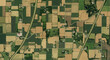 © arozzmer - Aerial top-down perspective of a vast rural landscape, a patchwork mosaic of agricultural fields, farms, and winding country roads
