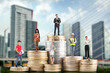 © New Africa - Personal wealth. People of various professions standing on different stacks of coins according to their salaries against cityscape