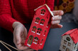 © anna.stasiia - Process of preparing for Christmas and New Year eve. 3D craft wooden houses DIY. Responsible ecological zero waste handmade decoration. Children hobby activity Home decor