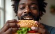 © nana - Close-up of black  man eating healthy sandwich at home. High quality