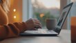 © D.APIWAT - Person typing on laptop keyboard at cozy home desk in warm evening light, focusing on remote work and digital connectivity for modern lifestyle.