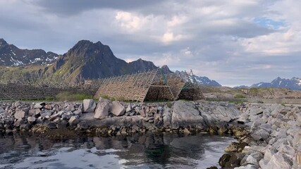 Wall Mural - Traditional wooden racks for drying codfish stockfish on rugged Norwegian coast