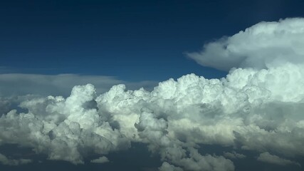 Wall Mural - A cockpit view in a high-altitude flight through threatening massive storm clouds at nightfall, with a darkening blue sky.