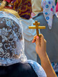 © HJBC - Femme russe de dos portant un foulard pour l'église sur la tête et tenant une petite croix orthodoxe dans la main pendant une procession. Concepts de religion chrétienne orthodoxe et de foi religieuse