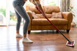 © Iryna - Woman cleaning hardwood floor in modern living room on a bright sunny day