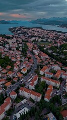 Wall Mural - Aerial drone flies over east Dubrovnik, capturing mountains, the Adriatic Sea, and autumn foliage glowing warmly in golden light during a calm sunset along the scenic Croatian coastline.