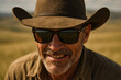 © DAndreev - Rugged cowboy in wide-brimmed hat wearing denim shirt in open prairie landscape