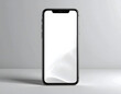 © Kholik - A black smartphone with a blank white screen is displayed on a light grey surface, casting a soft shadow.