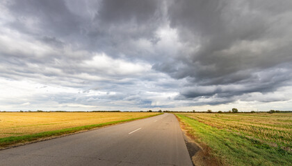 Wall Mural - Road with a cloudy sky in the background