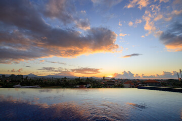 Wall Mural - Beautiful sunset over a pool with a city in the background