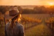 © Maryna - Texas Wine Country. Beautiful Caucasian Female in Cowboy Hat in Vineyard at Sunset