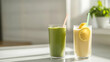 © photo for everything - Two smoothies, one green and one yellow, sit on a white counter, backlit by sunlight, offering a refreshing and healthy beverage option.