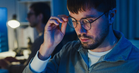 Team adult male freelance developer work late use tablet write prompt AI bot app program nomad terminal code at office night. Artificial intelligence dashboard, robotics, interface, machine learning.