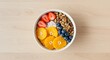 © Premium Resource - Overhead shot of a bowl of granola with fruit on a wooden table