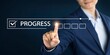 © Nayan - Businessman's finger activating a progress bar with the word PROGRES and completed checklist items