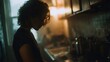 © Thares2020 - Woman in silhouette cooking in a moody dimly lit kitchen with steam rising