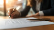 © photo for everything - Business professional signing a document. Focused on the pen, paper, and signing process. Bright indoor setting, natural light adding ambiance.