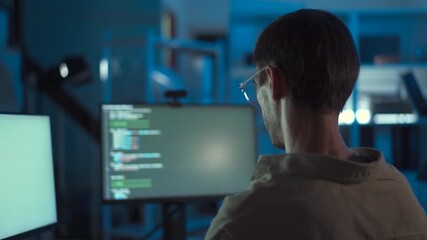 Nighttime programmer working with focus in his tech workspace.