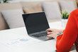 © PRIME STOCK LAB - Woman working on laptop at desk with business chart and plant, productivity focused and calm