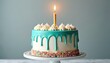 © miss irine - Festive cake on stand has teal icing drip and sprinkles. Burning candle. Sweet dessert for birthday party one year anniversary celebration food treat confection sugary goodness.