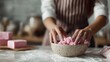 © Thares2020 - Hands mixing pink ingredients for handmade soap in a domestic kitchen setting dusted with white powder