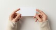 © Abdul Basit - Professional presentation photo of two hands holding a blank greeting card or gift card horizontally