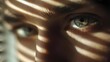 © Anastasiia - Close-up of a blue eye peering through striped shadows cast by blinds. Concept Close-up eye portrait, Blue iris detail, Striped light shadows, Blinds light pattern, Moody high-contrast