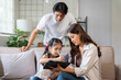 © amnaj - Asian parents and child connecting while drawing and learning on a digital tablet at home, promoting modern education