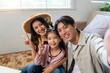 © amnaj - Happy Asian family taking a selfie together, showing peace signs, enjoying quality time, and celebrating holidays