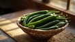 © Abuzar - Fresh green chili peppers in a woven basket bathed in soft window light indoors