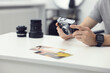 © New Africa - Professional photographer with vintage camera at white table in studio, closeup