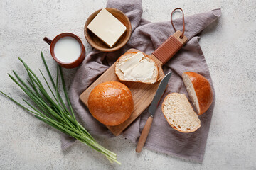 Wall Mural - Sliced bread with butter, green onion and cup of milk on light background