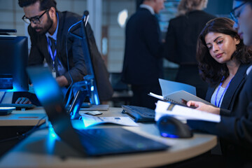 A senior IT specialist guides a new female software developer through the company's system architecture, providing hands-on support during her technical onboarding in a modern tech hub.