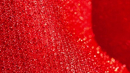 Red glitter macro background with shining bokeh .iridescent gradient texture.Folds of shiny fabric in red tones. 4k footage