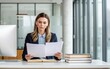 © Tonton1541 - leadership education sector concept. Professional woman reviewing documents in a modern office setting.