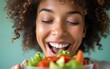 © ning - Below view of woman with eyes closed enjoying in a taste of healthy salad. High quality