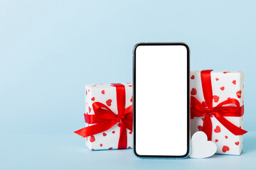 Wall Mural - mobile phone with blank screen on colored background with hearts, calendar and gift box, valentine day concept perspertive view flat lay