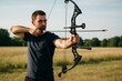 © Who is Danny - Focused man aiming modern compound bow in field under clear sky, practicing archery with natural background in soft light outdoors. Ai generative