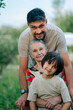 © Westend61 - Grandmother, man and grandson smiling together outdoors in nature
