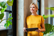 © BusinessClass by W61 - Smiling businesswoman in modern office holding tablet near window