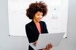 © BusinessClass by W61 - Businesswoman with laptop standing in front of whiteboard at office