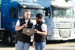 © Serhii - Truck drivers discussing logistics using laptop at fleet parking