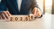 © Visual Verse - Business professional expertly arranges wooden blocks to display the year 2026, signifying future planning and strategic growth opportunities