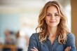 © Ilja - Confident Businesswoman Posing with Arms Crossed in Modern Office, Exuding Professionalism and Charm