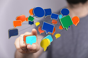 Wall Mural - Concept of communication network with speech bubbles. Man pointing to a floating network of conversation bubbles. Ideal for illustrating online
