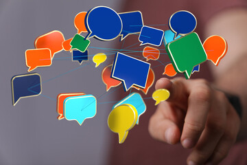 Wall Mural - Hand interacting with a network of colorful speech bubbles, symbolizing global communication and connection.