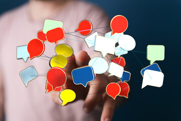 Wall Mural - Conceptual image of hand interacting with network of colorful speech bubbles. Represents communication, social media, online conversation, and d