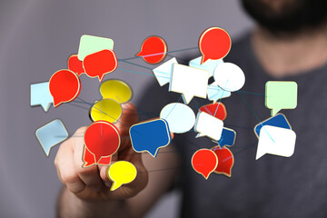 Hand interacting with communication network of colorful 3d speech bubbles. Illustrates connectivity, social media and modern communication.