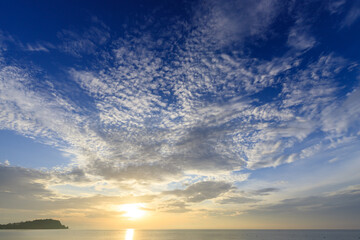 Wall Mural - The sky is blue with a few clouds and the sun is setting