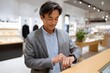 © Галя Дорожинська - Middle-aged man checks digital receipt on smartwatch in store Generative AI